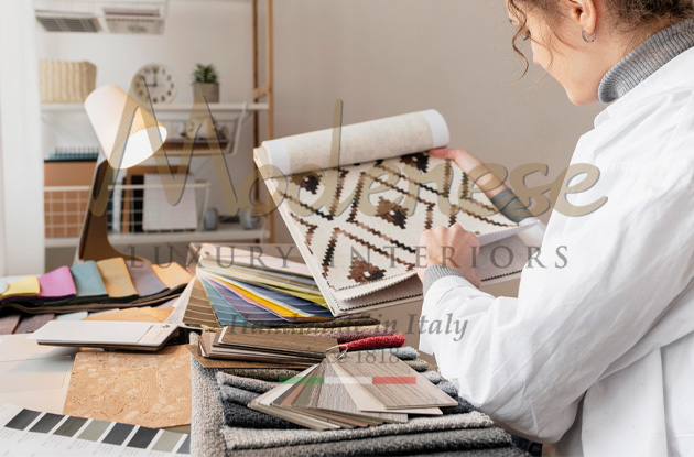 Designer looking at fabric samples and colors on a table Modenese Luxury Interiors