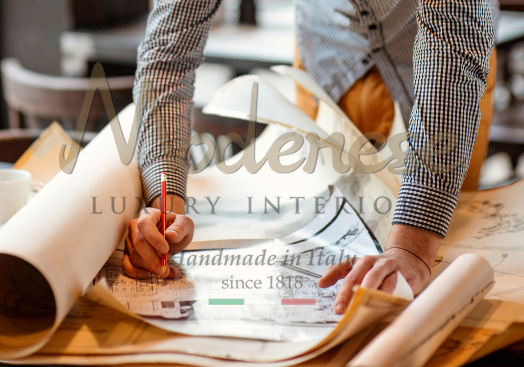 Modenese designer working on layouts for interior design projects on a table full of papers