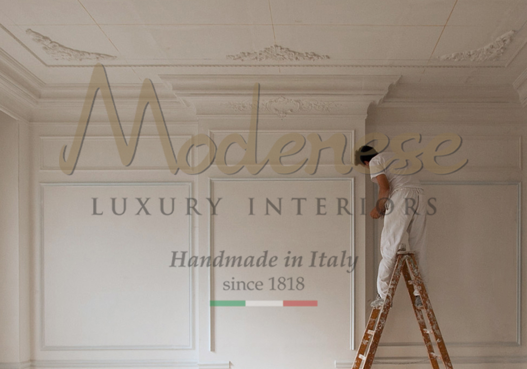 Worker on ladder decorating a wall with gypsum classic design Modenese