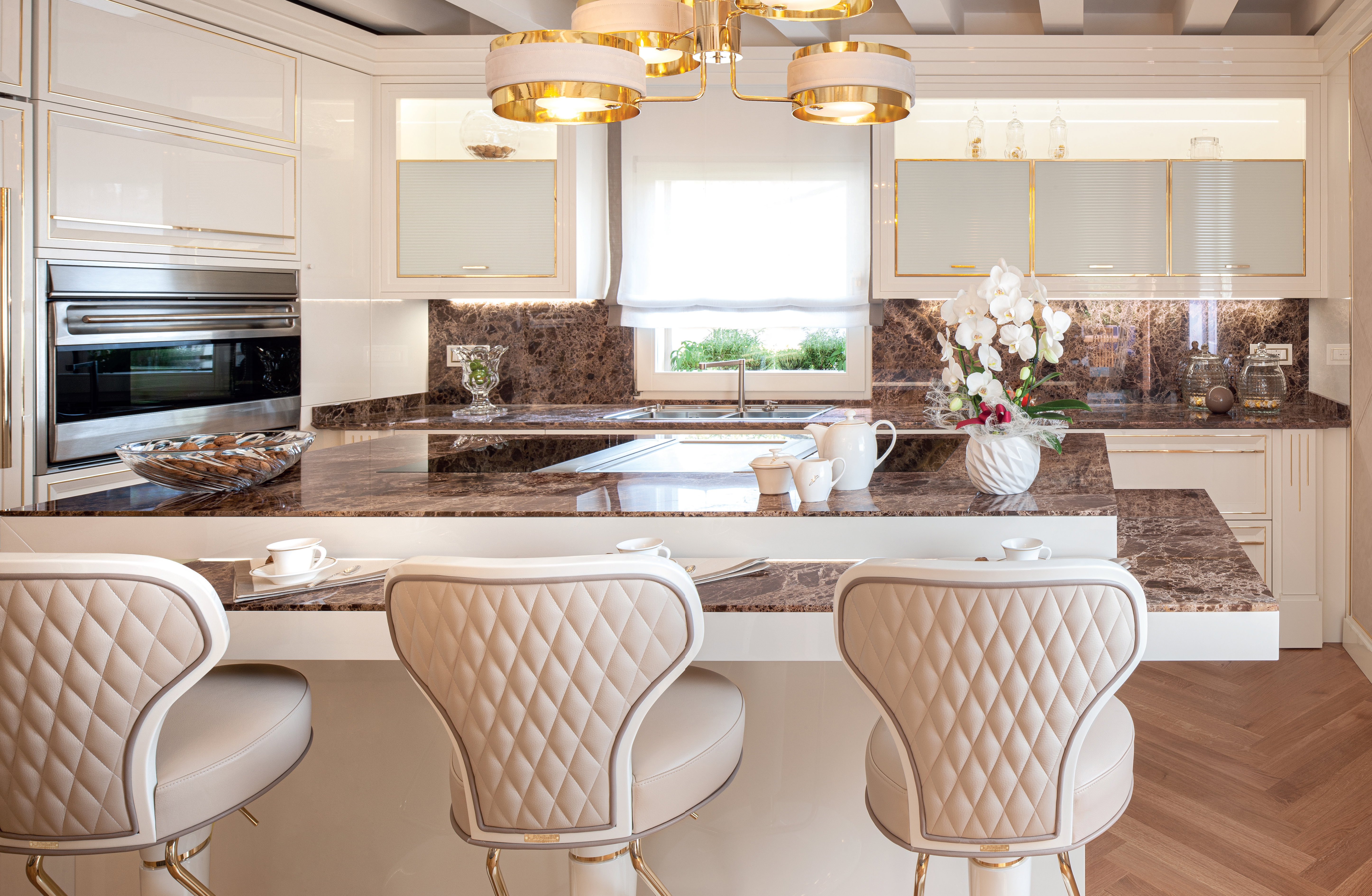 Kitchen island with breakfast area and quilted upholstered stools in the Prestige kitchen, Abu Dhabi