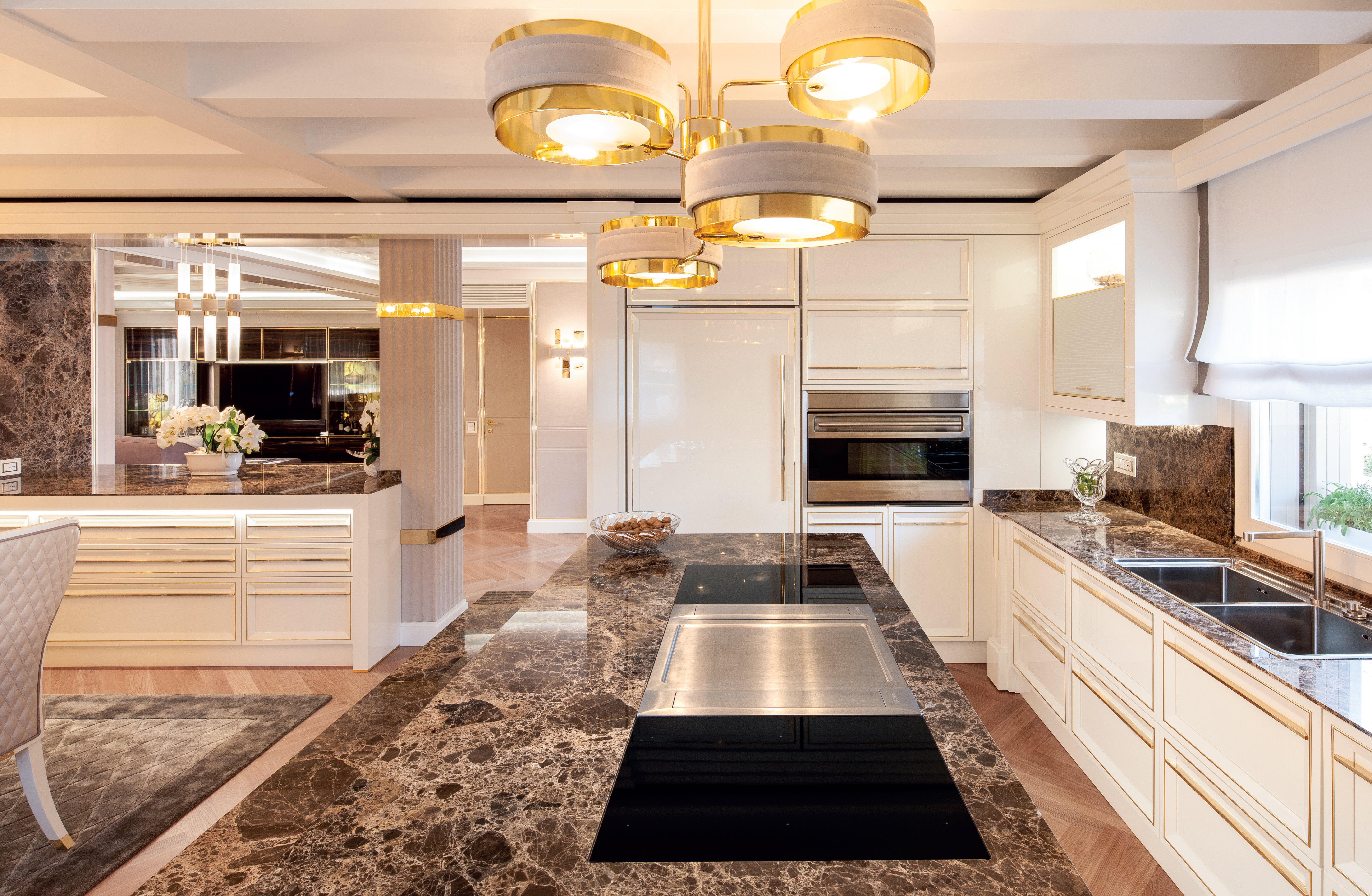 Prestige contemporary bespoke Italian kitchen in Abu Dhabi with ivory cabinetry, dark marble island and gold accents